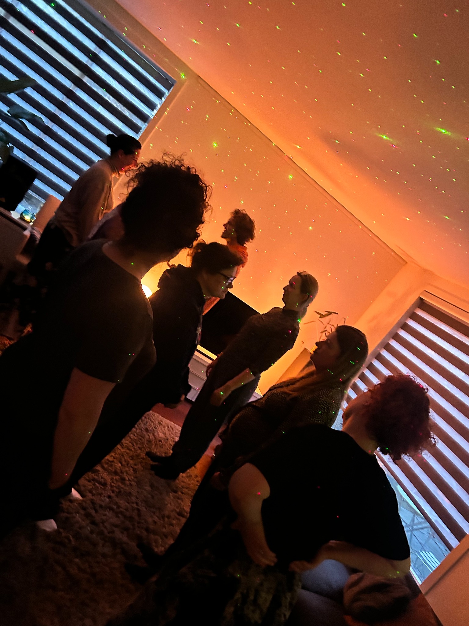 Een groep deelnemers in een sfeervol verlichte woonkamer tijdens een sessie